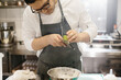 © dsheremeta - The middle section is a portrait of a chef grating lime zest. The concept of cooking in a restaurant.