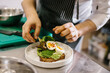 © dsheremeta - The chef is preparing food. Close-up of a male chef preparing avocado toast in a spacious modern kitchen.