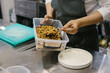 © dsheremeta - The process of making muesli in a restaurant, a male chef is working in the kitchen.