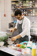 © dsheremeta - Preparing vegetables for a delicious bowl dish: a male chef in a contemporary restaurant kitchen.