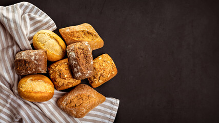 Wall Mural - Buns on a striped towel on a dark background. View from above