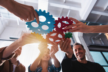 Wall Mural - Business team connect pieces of gears. Teamwork, partnership and integration concept