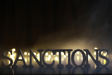 Wall Mural - Word Sanctions made of wooden block letters with dramatic lighting and smoke