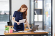 © David - Asian Businesswoman Using laptop computer and working at office with calculator document on desk, doing planning analyzing the financial report, business plan investment, finance analysis concept.