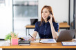 © David - Cheerful business Asian woman freelancer making telephone call share good news about project working in office workplace, business finance concept.