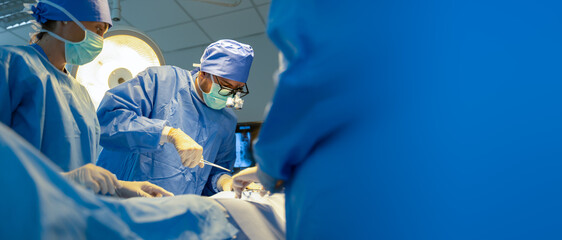 Wall Mural - group of surgeons doing surgery in hospital with reflection in glasses.team of professional mixed-ra