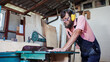 © Branimir - Carpenter using working tools while working on a wood in carpentry workshop