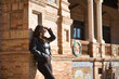 © Manuel - Young, beautiful, Latin and South American woman with leather top and jacket, sunglasses and jeans, leaning against a brick wall, posing sensual and attractive. Concept beauty, fashion, diversity.