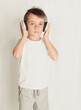smiling little boy with headphones at home