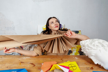 portrait of a creative young woman sitting at a desk in her workshop, wearing a tudor collar made of