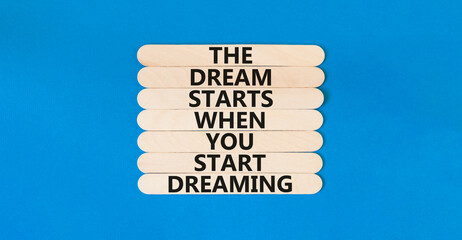 Start dreaming symbol. Concept words The dream starts when you start dreaming on wooden stick. Beautiful blue table blue background. Copy space. Motivational business start dreaming concept.