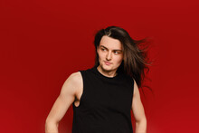 Studio Portrait Of Young Man With Waiving Long Hair