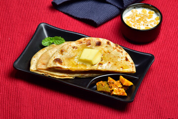 Wall Mural - Butter stuffed paratha served with raita, healthy indian breakfast