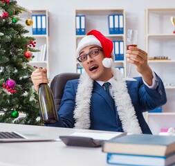 Wall Mural - Businessman celebrating christmas holiday in the office