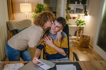 Young man and his mother woman hold paper read good news in letter sit at desk at home beautiful female received correspondence bank statement or notification invitation scholarship pleasant message