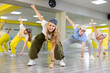 © JackF - Active teenage girl practicing breakdance go downs in training hall. Teenagers engaged in breakdance in dance studio