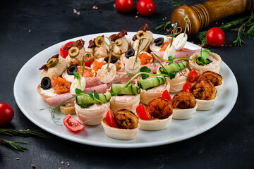 Wall Mural - Set of bruschetta with pate, dried tomatoes and olives, tartlets with cream cheese and salmon, cheese and cucumber, ham and egg, shrimps and tomatoes.