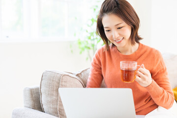 Wall Mural - 部屋でラップトップコンピューターを見る女性