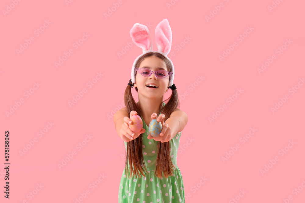 Cute little girl in bunny ears on pink background