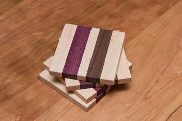 Wall Mural - Set of four hardwood coasters with different layers of maple, walnut and purple heart wood