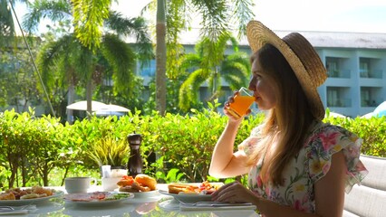 Wall Mural - Woman enjoying morning meal in luxurious tropical hotel