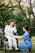 © Nuttapong punna - Elderly asian senior woman on wheelchair with Asian careful caregiver. Nursing home hospital garden concept. in sun light