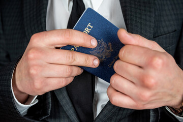 business man wear suit holding U.S. passport