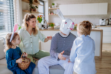 Wall Mural - Little children having fun with her mother and Easter rabbit, celebrating Easter.