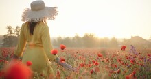 Brunette Woman In A Yellow Dress And Straw Hat In Poppy Field At Sunrise. Harmony, Love, Nature Concept