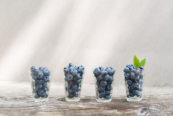 Poster - blueberries in a glass bowl on a wooden background . summer fruit background