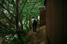 A Woman Walks Along The Path Between The Garages