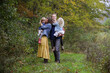 © Cavan Images - family of four happy together in wooded clearing during fall