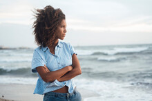 Contemplative Woman Standing With Arms Crossed At Beach