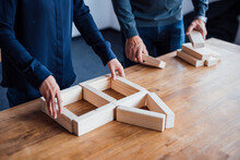 Business Colleagues Arranging Wooden Blocks In Office