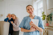 © Westend61 - Smiling nurse holding tablet PC with senior man and woman in background at home