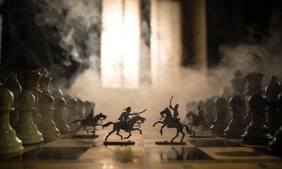 Wall Mural - Medieval battle scene with cavalry and infantry on chessboard. Chess board game concept of business ideas and competition and strategy ideas Chess figures on a dark background with smoke and fog.