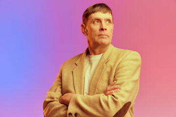 Portrait of mature, middle-aged man in jacket posing with serious face over gradient pink purple background in neon light. Concept of emotions, lifestyle, facial expression, fun. Ad