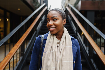 Portrait of smiling young black woman standing in the street