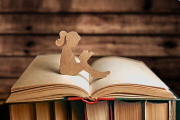 An introvert girl reads a book story against the background of books