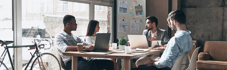 Canvas Print - Group of young people having business meeting while working in office together