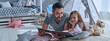 © gstockstudio - Father reading a book to his little daughter while lying on the floor at home together