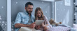 © gstockstudio - Happy father and his little daughter looking at digital tablet while sitting on the bed at home together