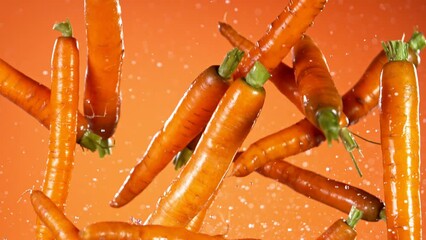 Poster - Super slow motion of fresh carrots with water splashes flying in the air. Filmed on high speed cinema camera, 1000 fps.