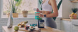 © gstockstudio - Close-up of sporty woman preparing protein cocktail in the kitchen