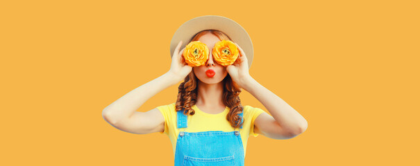 summer portrait of happy young woman covering her eyes with flowers as binoculars looking for someth