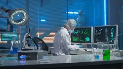 Wall Mural - Medical development laboratory. A female scientist types on a keyboard and enters research data. A female researcher against backdrop of a modern laboratory with test tubes, flasks and a microscope.