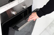 © Дмитрий Сидор - Man open modern electric oven, making dinner at home concept