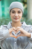 Fototapeta  - Happy smiling south asian Indian woman cancer patient wearing head scarf for hair loss after chemotherapy and radiation therapy showing heart hand gesture for cancer patient awareness