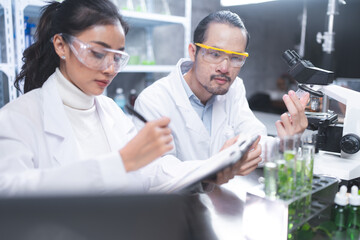 Wall Mural - Pharmaceutical factory woman worker in protective clothing operating production line in sterile environment, scientist with glasses and gloves checking hemp plants in a marijuana farm