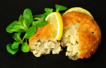 Wall Mural - Battered haddock and potato fish cakes with lemon and lambs leaf lettuce garnish